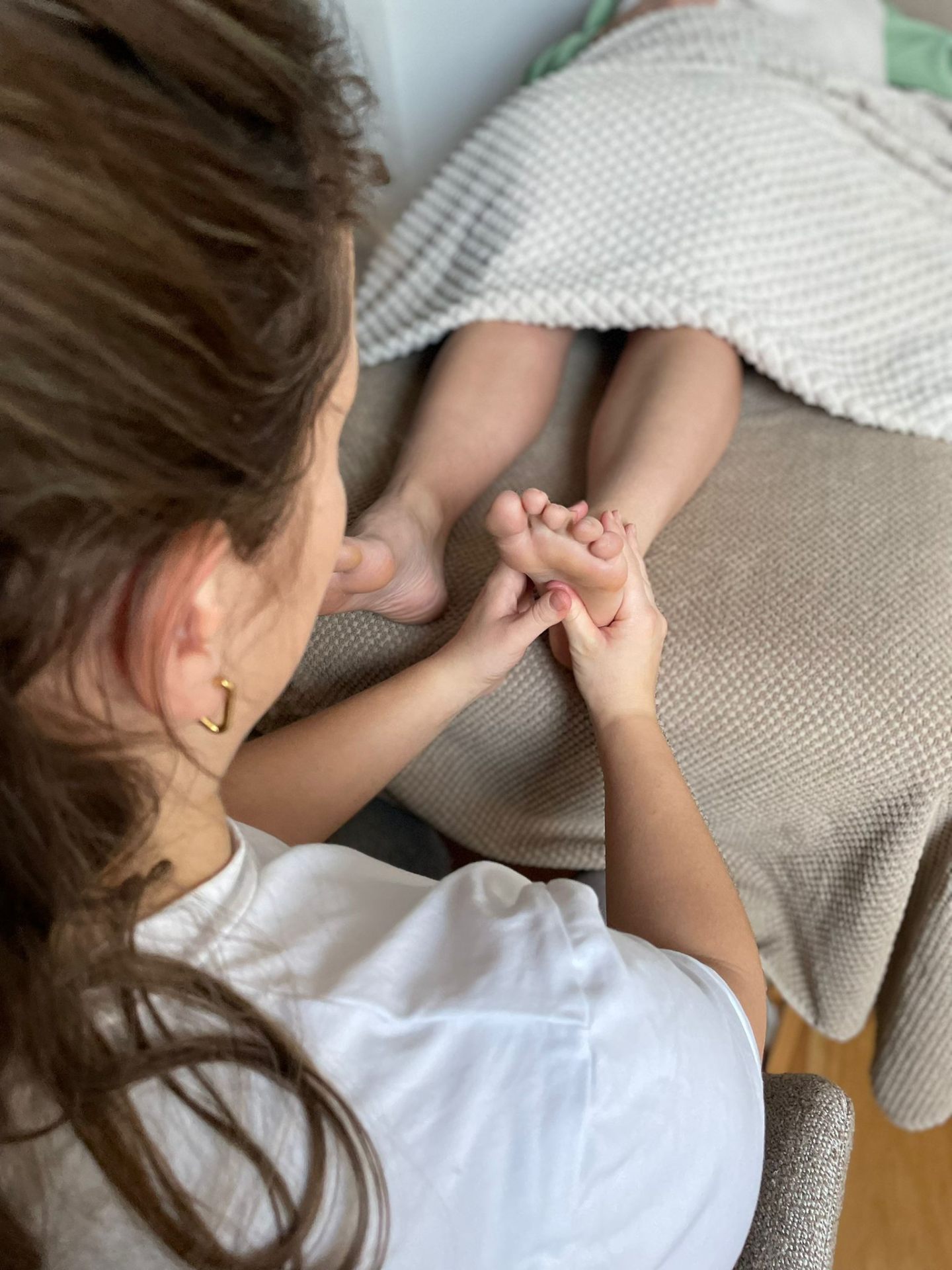 Romy geeft een voetreflexbehandeling in haar praktijk in Bladel